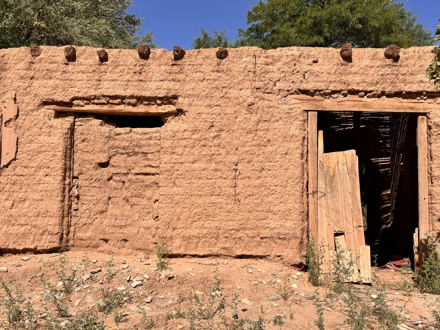 Una casa de adobe con su puerta de madera, en Aicuña