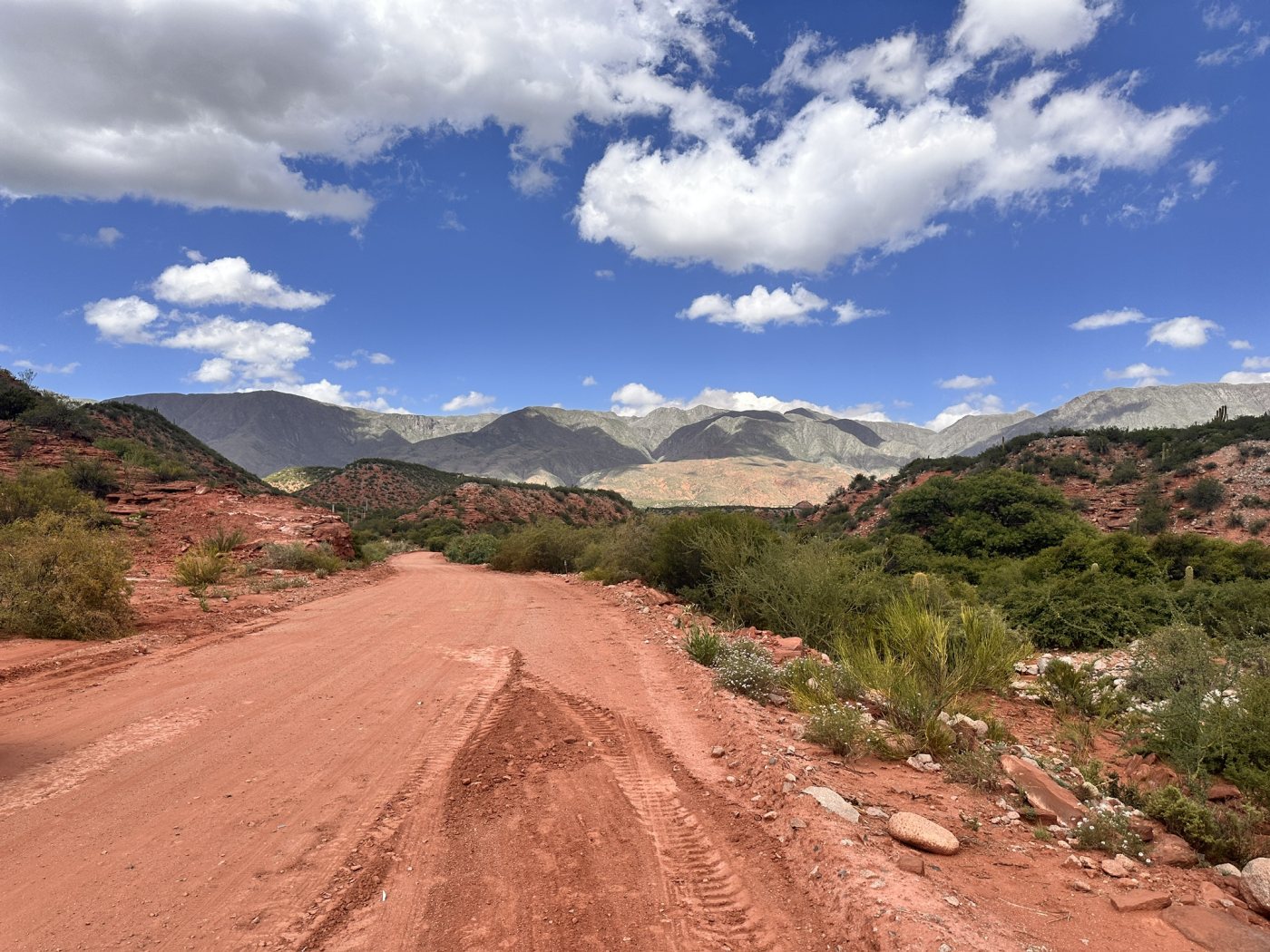 El camino de tierra roja hacia Aicuña, entre cerros y nubes